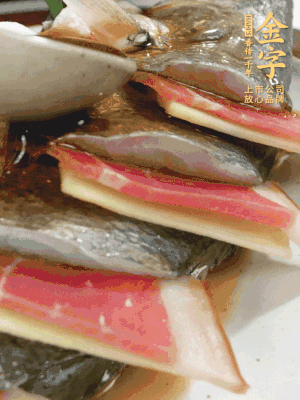 魚肚中塞蔥結(jié)、火腿片，魚身上碼放姜片、火腿片，倒入混合的料汁。