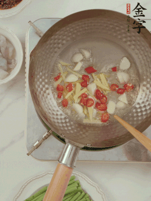 油7成熱時，下大蒜粒、姜絲、小米辣煸香。