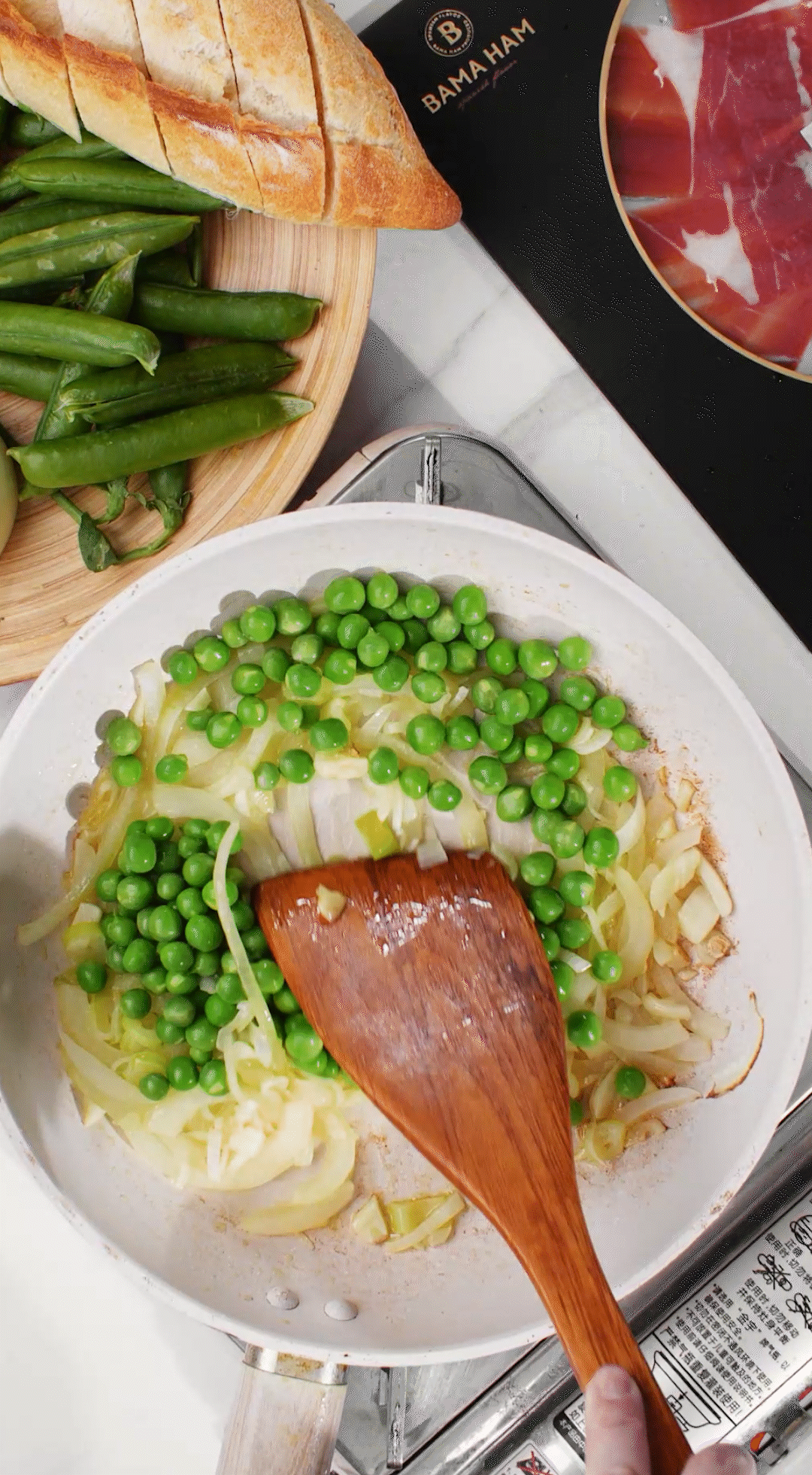 鍋中放入黃油融化，加入洋蔥絲、大蔥蔥白絲、蒜末翻炒變軟出香味。加入剛剛汆燙冰鎮(zhèn)后的豌豆，取出一點點待會擺盤裝飾用。加一點鹽 (和黑胡椒) 調(diào)味。
