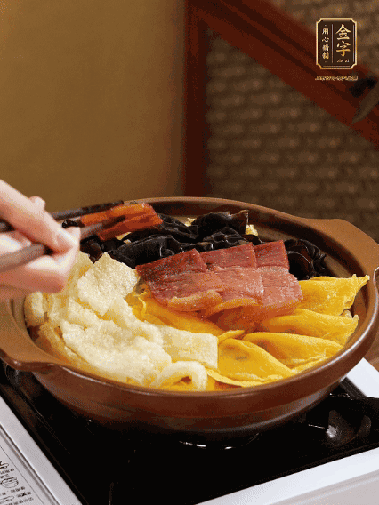 砂鍋底部鋪上娃娃菜，依次擺上肉皮、蛋餃、黑木耳、火腿